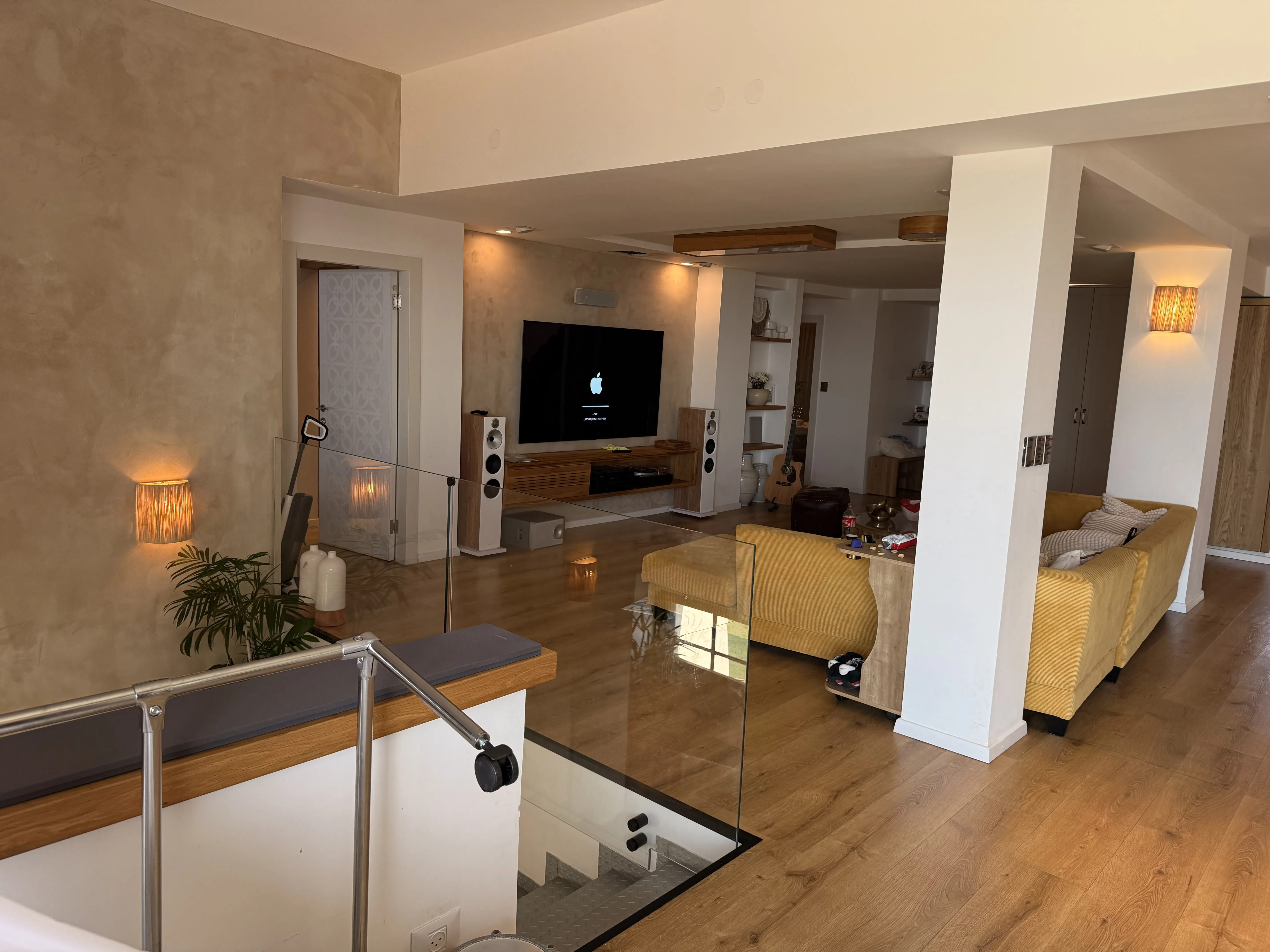 מערכת שמע אינטגרלית בחלל פתוח עם רמקולים לבנים וטלויזיה גדולה